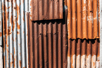 Old and rusty zinc sheet wall. Vintage style metal sheet roof texture. Pattern of old metal sheet. Rusting metal or siding. Corrosion of galvanized. Background and textures in retro concept.