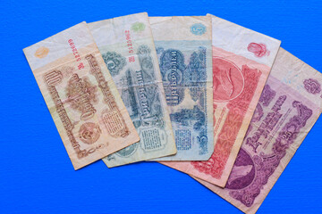 Old paper banknotes of the USSR, different denominations on a blue background