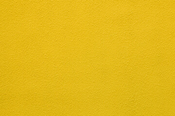 Yellow worn plaster on concrete wall.