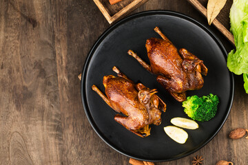 Traditional Cantonese roast pigeon on a and white porcelain plate