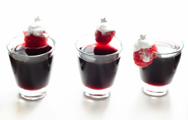 A festive red drink with a Christmas tree decoration made of raspberry and whipped cream