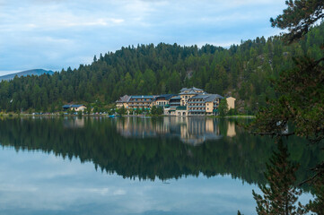 Romantischer Blick auf ein Hotel am Rand eines Sees mit den Bergen im Hintergrund