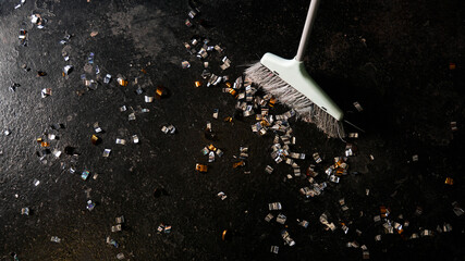 Cleaning broom and golden confetti on a black background. The concept of cleaning after the...