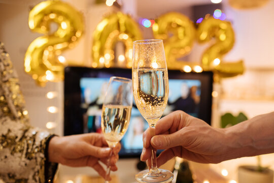 Christmas and New Year eve party 2022. Virtual work meeting in video call. Holiday office xmas at home. Decorate foil balloons of 2022 and Christmas lights. Champagne cheers for celebrate
