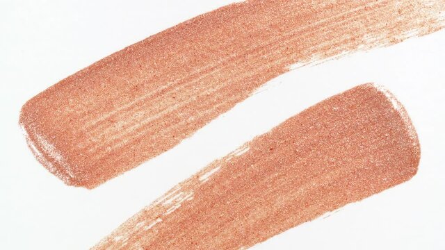 Macro shot and slow motion of a brush, applicator, smear, concealer isolated on white background. Advertising professional cosmetics. Closeup of a cosmetic liquid foundation. High quality 4k footage