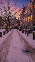 Snowy Amsterdam in winter in the Netherlands at sunset