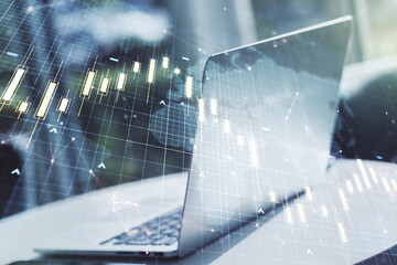 Double exposure of abstract creative financial chart with world map on laptop background, research and strategy concept