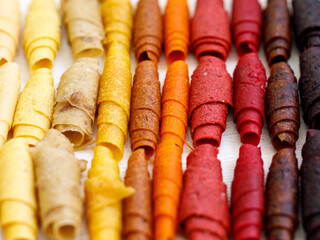 Assorted sweet pureed fruit pastille background. Different dried berries and fruits. mix of raspberries, currants, apples, strawberries, plum, cranberries, sea buckthorn, mango. healthy snack concept