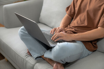 Work at home young asian man working on laptop computer while sitting at home Morning lifestyle