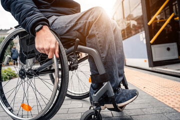 Obraz premium Person with a physical disability enters public transport with an accessible ramp.