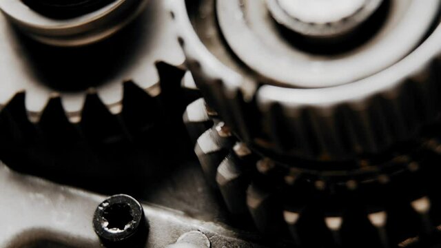 two engine gears start to move and stop and start again to move together (close up)