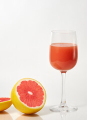 freshly squeezed grapefruit juice in a glass and red grapefruit wedges