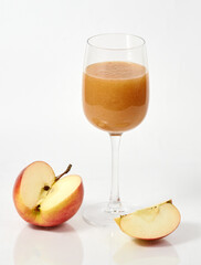 freshly squeezed apple juice in a glass and a cut apple