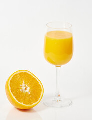 freshly squeezed orange juice in a glass and half an orange