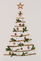 Christmas creative decoration - homemade wooden hanging christmas tree on the wall © Tunatura