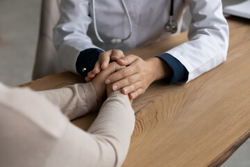 It will be all right. Close up view of female doctor gp hands hold caress palms of woman patient. Young lady general practitioner therapist physician comfort sick person give hope support care belief