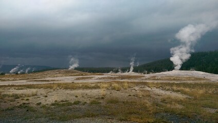 Fototapeta na wymiar Old Faithful erupting under stormy skies, Yellowstone National Park, Wyoming
