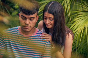 young couple looking a laptop and talking with her friends