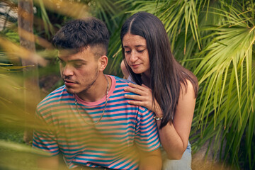 young couple looking a laptop and talking with her friends