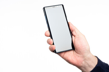 Phone hand close up. Man's hand demonstrates smartphone with screen to camera. Blank phone screen for advertising banner. Isolated hand with gadget. Place for applications. Copy space in display