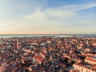 Fototapeta na wymiar Aerial view of a busy square at sunset near Venice. Panorama of the city from a drone overlooking the lagoon of the Adriatic Sea in northern Italy. Islands of Venice in the background.