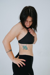 Obraz premium An ordinary young woman looks down on a white background. Bodypositive concept.