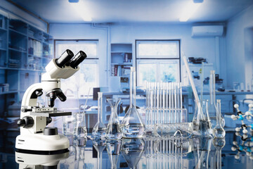 Laboratory investigations concerning test and medicine against covid. Microscope, glass tubes and beakers on blue background.
