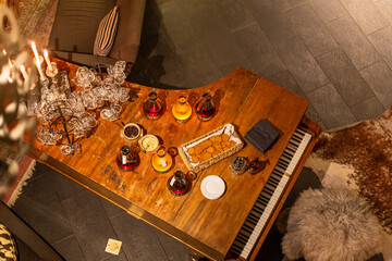 An interior with a grand piano as a server table. Holidays, wine and snacks. New year