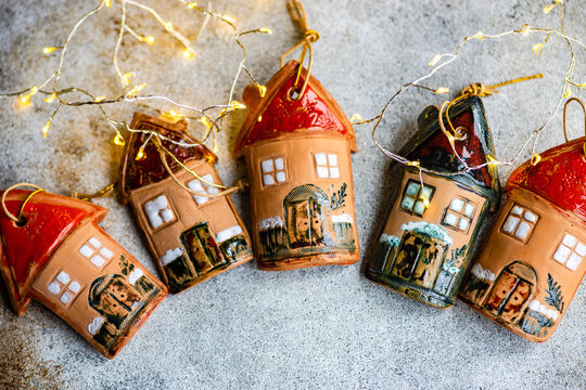Festive Christmas arrangement of five clay house ornaments with fairy lights
