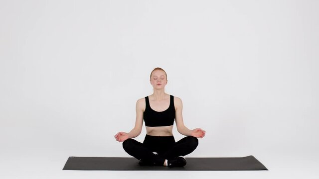 Yoga Class. Peaceful young woman meditating in lotus position in studio