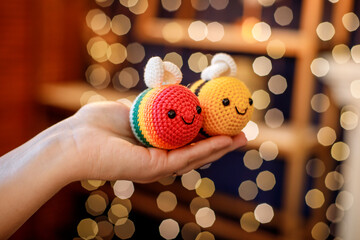 In the hands of a knitted toy for decorating a Christmas tree.