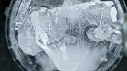 Detail shot of vodka drink pouring on rock ice