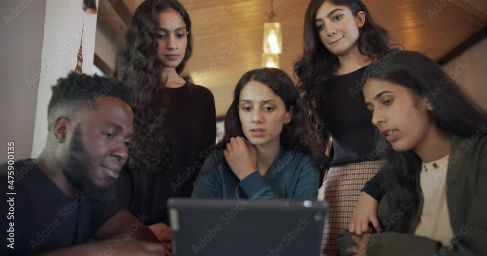 Canvas Prints A discussion of Indian friends around the table while looking at the tablet