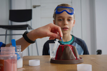 chłopak przeprowadza eksperyment naukowy z erupcją wulkanu 