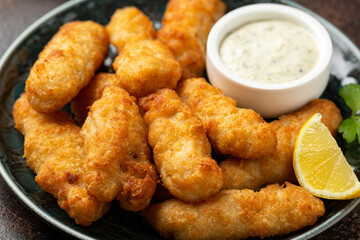 Crispy Fish strips with tartar sauce in a plate