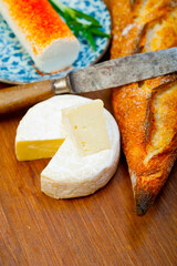French cheese and fresh  baguette on a wood cutter