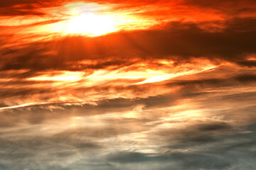 Fototapeta na wymiar The sun behind the clouds at sunset. Evening sky.