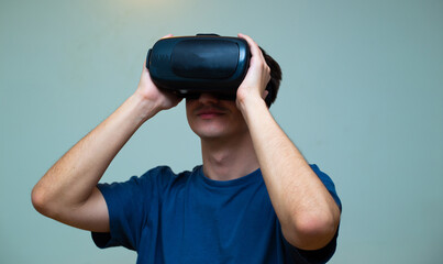 An excited young guy in virtual reality glasses is immersed in the metaverse