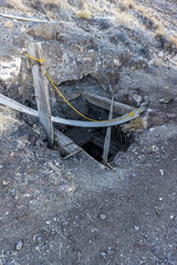 Roped off timbers warn people of the entrance to an old mine in the ground