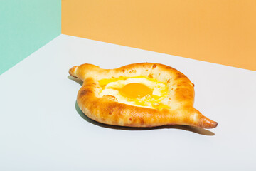 Closeup on caucasian flat bread adjarian khachapuri with egg on orange background