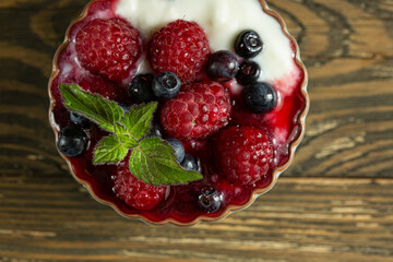 raspberries and blueberries in yogurt sauce in kremanka, top view. Juicy raspberries and blueberries. High quality photo
