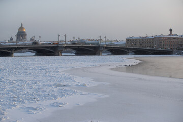 Winter panoramic view of St. Petersburg at frosty day, Isaac cathedral and Blagoveshenskiy bridge on background, steam over frozen Neva river, Admiralty building