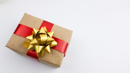 the gift is packed in a box of natural color. decorated with a red satin ribbon on a white background. packaging of gifts