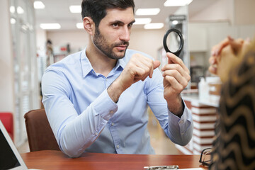 Male client asking question about magnifying glass