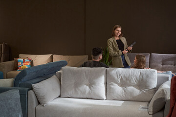 Joyful sales assistant standing before potential customers