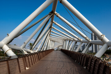 Naklejka premium An unusual spiral-shaped bridge made of metal pipes and wood
