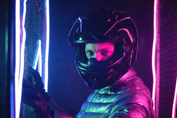 Obraz na płótnie Canvas A portrait of motorbiker in the helmet in the neon lights.