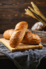 Fresh wheat bread on wooden cutting board