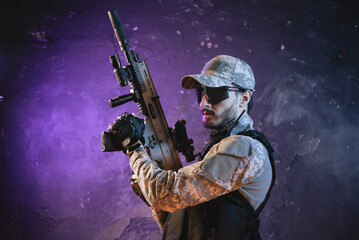 Fototapeta premium Futuristic soldier with a rifle on the black smoky background.