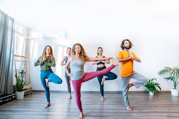 Fototapeta na wymiar Man and women doing yoga in studio